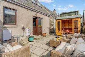 a patio with wicker furniture and a table at 3 Bed in Pitlochry oc-t37864 in Pitlochry