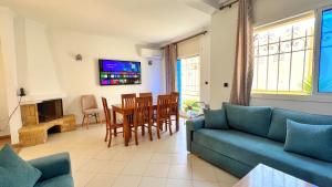 a living room with a couch and a table and chairs at Spacious Triplex in Harhoura in El Harhoura