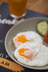 two fried eggs on a plate with a glass of beer at Filek House in Sibiu