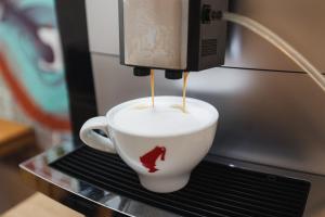 a coffee cup is being brewed in a coffee machine at Filek House in Sibiu