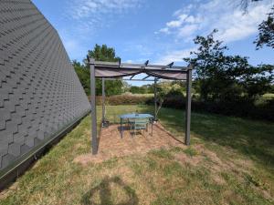 a table and chair under a canopy in a yard at Tipi Big Foot in Vivy