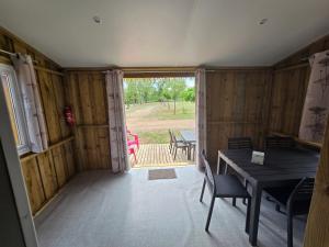 a dining room with a table and a window at camping la plage de l'orb in Cessenon