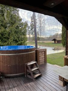 a jacuzzi tub on a wooden deck with a table at 5 bedroom house in Roosisaare