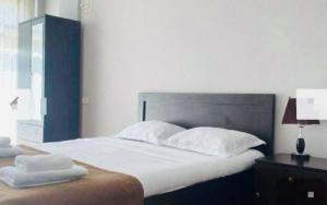 a bedroom with a large bed with white sheets and pillows at Saburtalo Central in Tbilisi City +2 photos