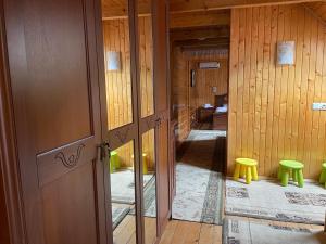 a room with wooden walls and a hallway with yellow stool at Guest house Nad Tisou in Kvasy