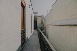 an alley between two white buildings with a fence at Hotel Boutique Casa Yága in Querétaro