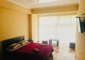 a bedroom with a red bed and a table at Saburtalo Central in Tbilisi City