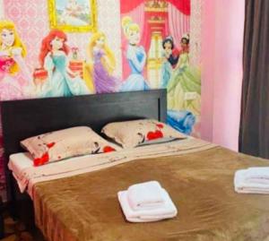 a bed with two towels and a painting on the wall at Saburtalo Central in Tbilisi City