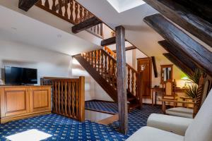 a living room with wooden stairs and a television at LH Hotel Gold in Český Krumlov