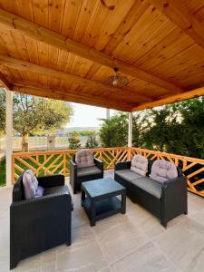 a patio with couches and a table and a wooden ceiling at Vila Mehmeti in Delvinë