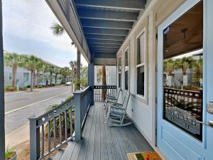 a porch with two chairs on a house at The Holland House II in Rosemary Beach