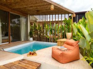 a patio with a chair next to a swimming pool at Thara Coco Villa - Boutique Luxury In Srithanu in Hinkong
