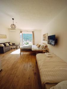 a bedroom with two beds and a large window at Villa Olea in Mostar