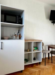 a white book shelf with a microwave and a table at POKLEKANE in Wysowa-Zdrój