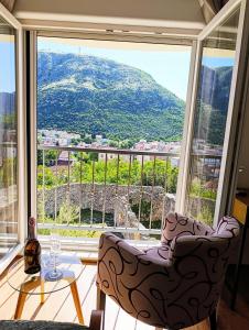 a room with a large window with a chair and a table at Villa Olea in Mostar