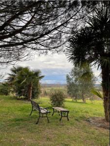 a bench and a picnic table in a field at Mon Hacienda in Caumont