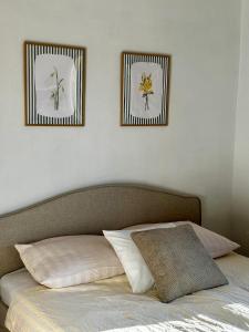 a bed with two pictures on the wall above it at POKLEKANE in Wysowa-Zdrój