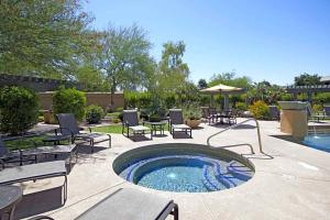 a patio with a hot tub and tables and chairs at 2 Bedroom 2 Bathroom Ground Floor Condo Ahwatukee in Phoenix