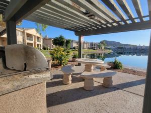a patio with a table and a grill with a view of the water at 2 Bedroom 2 Bathroom Ground Floor Condo Ahwatukee in Phoenix