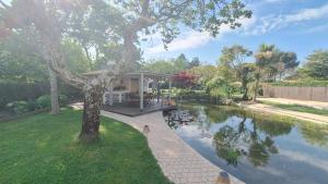 a house with a pond in the yard at Villa du Rosais in Saint-Hilaire-de-Talmont