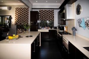 a kitchen with white counter tops and black cabinets at LeoLapa in Hectorspruit +34 photos