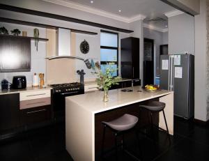 a kitchen with a counter with a vase of flowers on it at LeoLapa in Hectorspruit