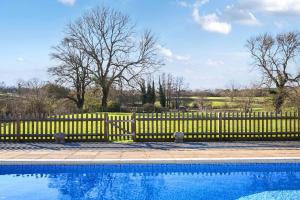 a yellow fence next to a swimming pool at Blackham Farm in Hartfield