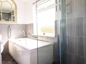 a bathroom with a tub and a glass shower at Tregoning in Lostwithiel +24 photos