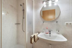 a bathroom with a sink and a shower with a mirror at Getzenbergerhof in Chienes +55 photos
