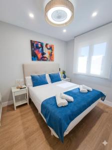 a bedroom with a large bed with a blue blanket at Tu Refugio en el Centro Histórico de Castro in Castro-Urdiales