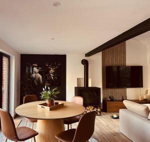 a living room with a table and a tv at Nid cosy en forêt in Blaimont