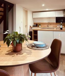 a kitchen with a wooden table with a plant on it at Nid cosy en forêt in Blaimont