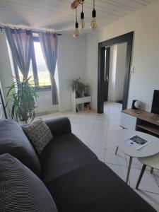 a living room with a couch and a table at Logis des Bouchons in Morteau
