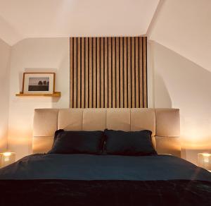 a bedroom with a bed with a large headboard at Nid cosy en forêt in Blaimont