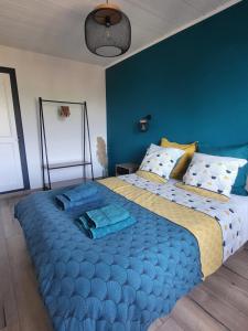 a bedroom with a large blue bed with blue walls at Logis des Bouchons in Morteau