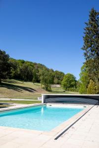 a swimming pool on the side of a house at DomaineduRocBlanc in Merey