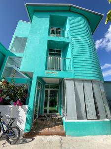 a blue building with the front door open at Green Villa in Huraa