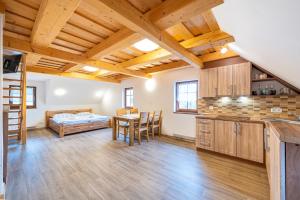 a kitchen with a table and a bed in a room at Apartmány Studený in Kunratice