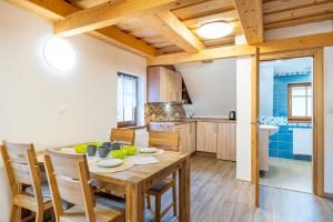 a kitchen and dining room with a wooden table and chairs at Apartmány Studený in Kunratice +27 photos