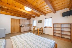 a bedroom with a bed and a table and a kitchen at Apartmány Studený in Kunratice