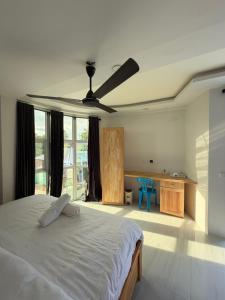a bedroom with a bed and a ceiling fan at Green Villa in Huraa