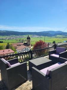 a balcony with chairs and a view of a town at Logis des Bouchons in Morteau