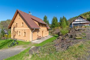 a house on a hill with a bike in front of it at Apartmány Studený in Kunratice