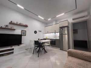 a kitchen with a table and a tv in a room at Beach House Gjiri i Lalzit in Mullini i Danit
