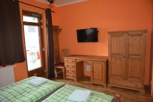 a bedroom with a desk and a tv on the wall at Hotel HAVLOV in Žďárec