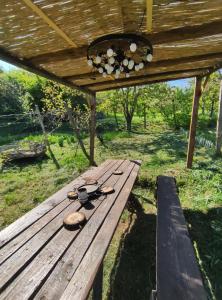 a picnic table with glasses and a chandelier on it at Menyecske Guesthouse in Keszü