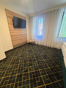 a room with a flat screen tv on a wall at Royal Apartamenty in Bytom