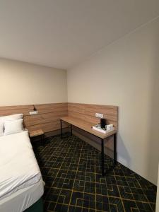 a room with a bed and a desk in it at Royal Apartamenty in Bytom