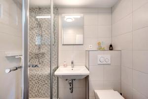 a white bathroom with a sink and a shower at Chalet Seewald - Apartment in Seewald