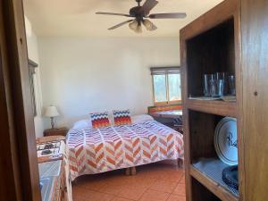 a bedroom with a bed and a ceiling fan at Casitas Las Palmas - Brisa Marina in Punta Mita